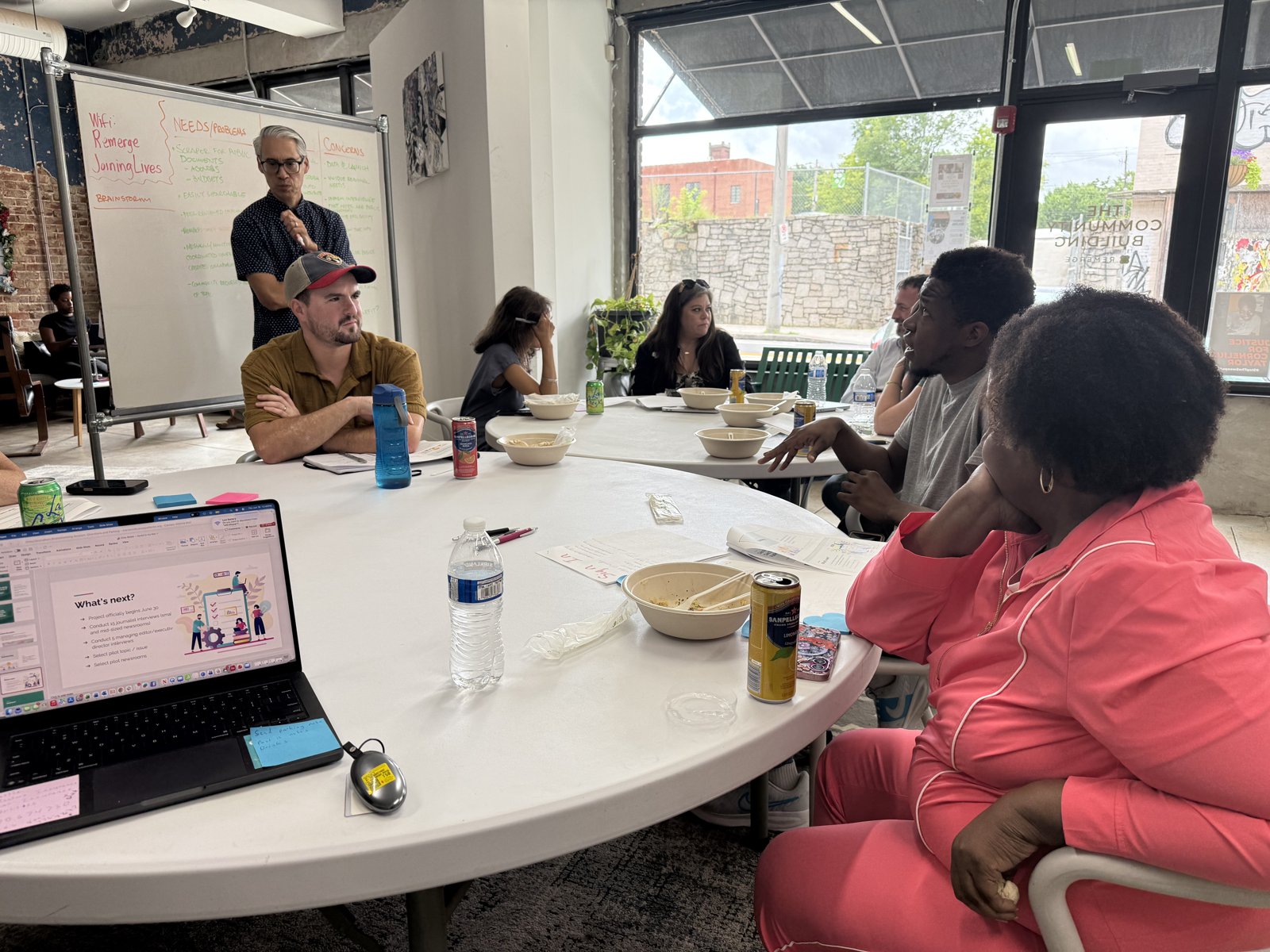 A facilitator presenting next steps to the group around a shared table